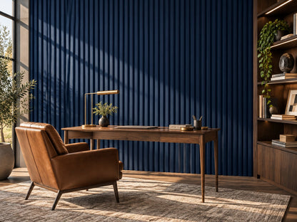 Home office with navy grooved wall panels behind a walnut desk and leather chair